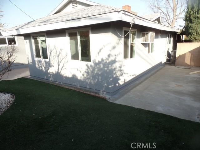 view of side of property with a yard and a patio