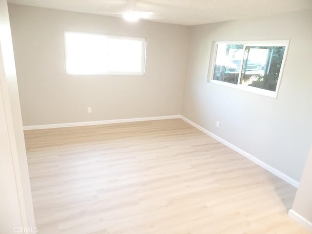 spare room featuring light hardwood / wood-style floors and a healthy amount of sunlight