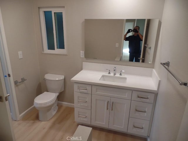 bathroom featuring vanity, wood-type flooring, and toilet