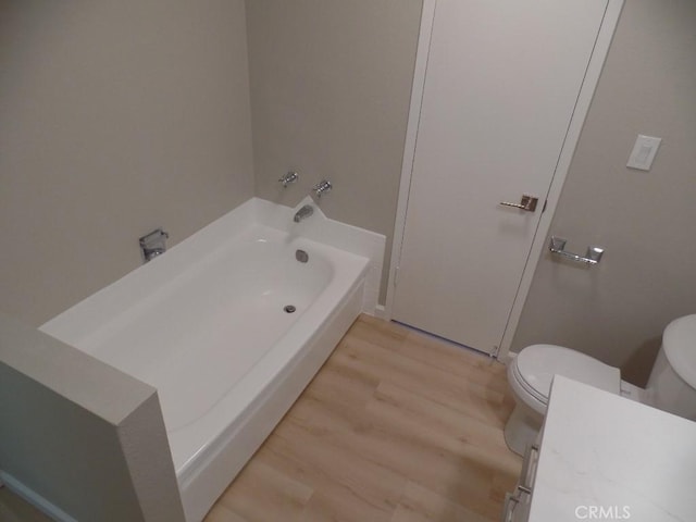 bathroom with hardwood / wood-style flooring, a bathtub, and toilet