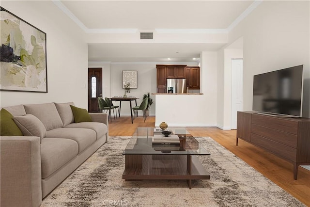 living room with ornamental molding and light hardwood / wood-style floors