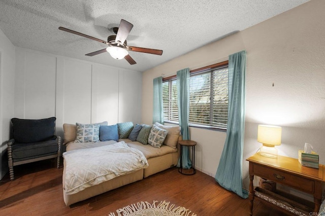 bedroom with ceiling fan, dark hardwood / wood-style floors, and a textured ceiling