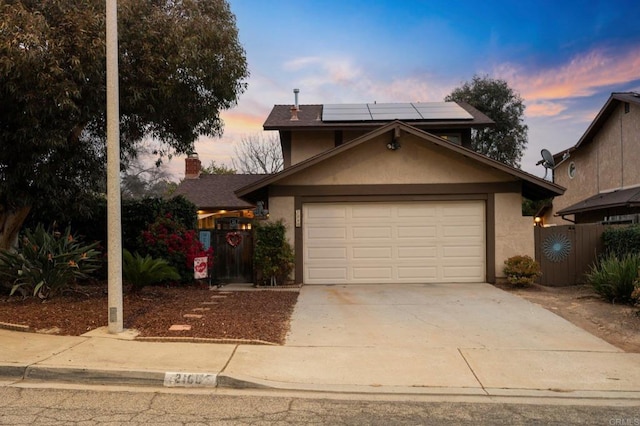 view of front property featuring a garage and solar panels