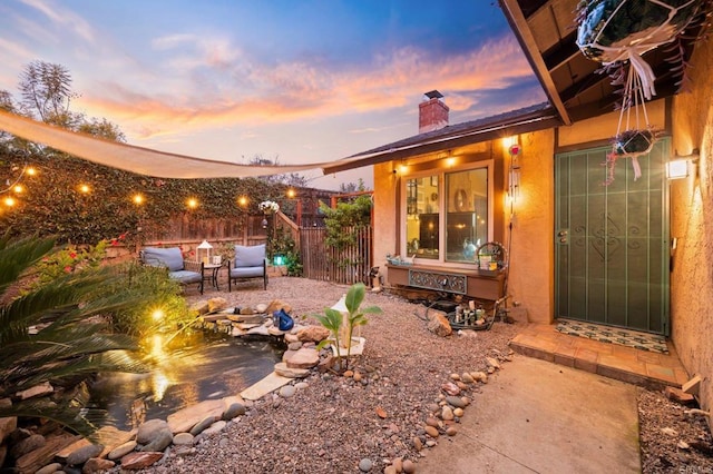 yard at dusk featuring outdoor lounge area and a patio area