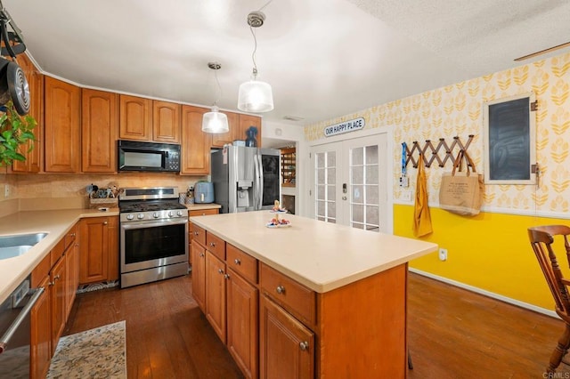 kitchen with french doors, a center island, hanging light fixtures, appliances with stainless steel finishes, and dark hardwood / wood-style flooring