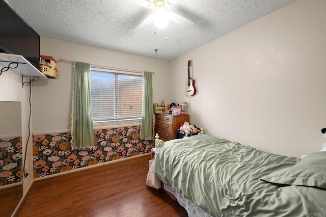 bedroom featuring ceiling fan, dark wood-type flooring, and a textured ceiling