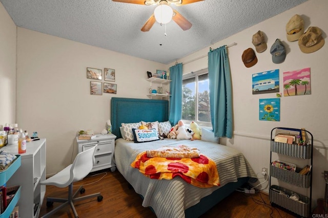 bedroom with dark wood-type flooring, ceiling fan, and a textured ceiling