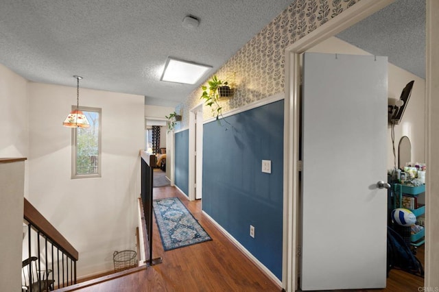 corridor with hardwood / wood-style flooring and a textured ceiling