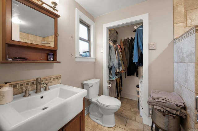 bathroom with vanity, tasteful backsplash, and toilet