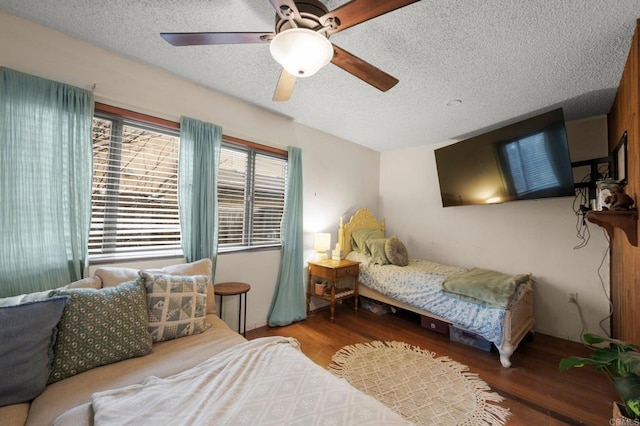 bedroom featuring ceiling fan, dark hardwood / wood-style floors, and a textured ceiling