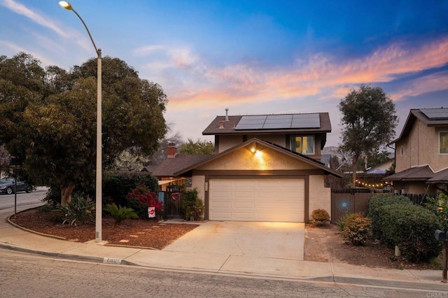 view of front of home with a garage and solar panels