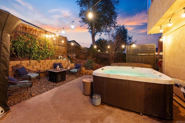 patio terrace at dusk with a hot tub and a fire pit