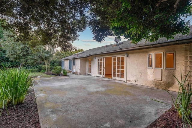 back of house with stucco siding and a patio