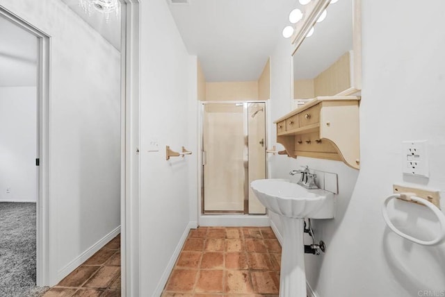 full bathroom featuring a shower stall and baseboards