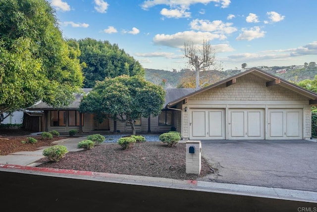 view of front of house with aphalt driveway, an attached garage, and a mountain view