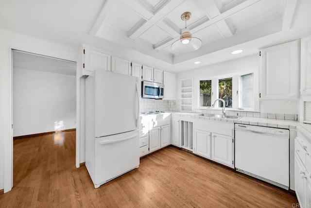 kitchen with light wood finished floors, light countertops, white appliances, and white cabinets