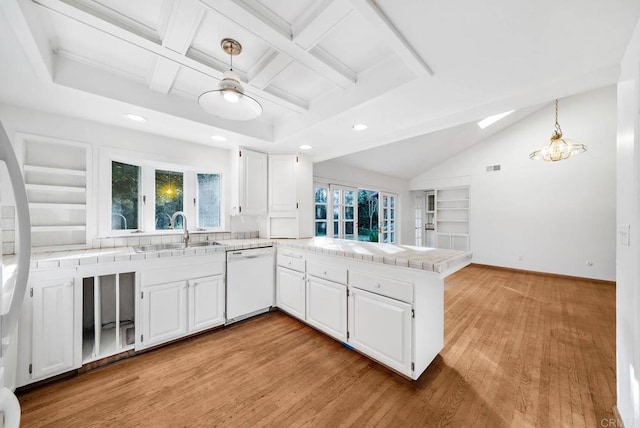 kitchen with pendant lighting, white cabinetry, a sink, dishwasher, and a peninsula