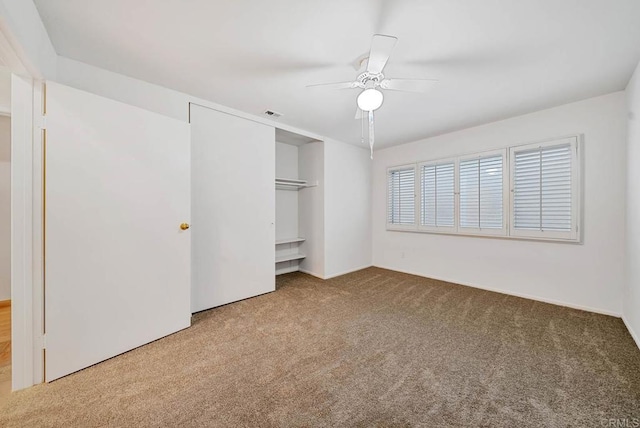 unfurnished bedroom featuring a ceiling fan, carpet, visible vents, and a closet