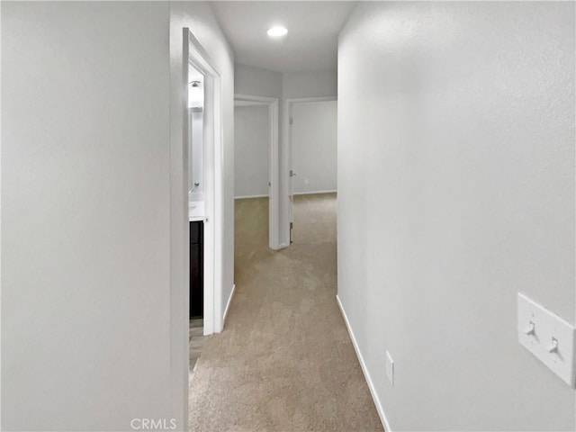 hall featuring light colored carpet