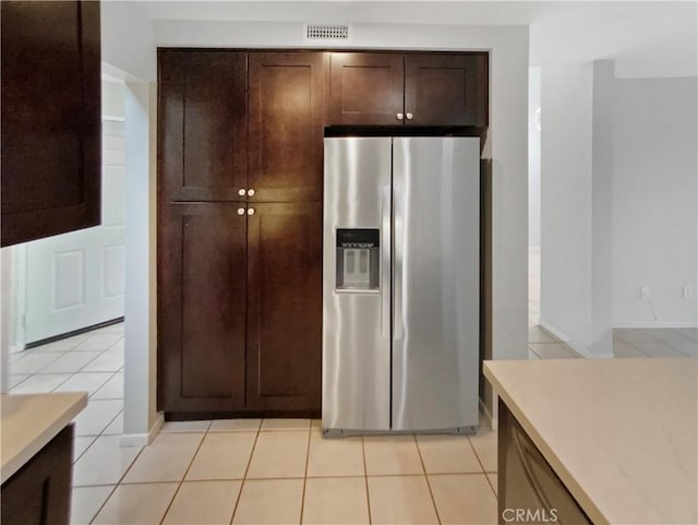 kitchen featuring light tile patterned flooring and stainless steel refrigerator with ice dispenser