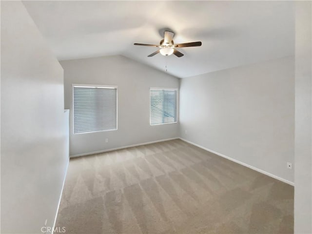 carpeted empty room featuring ceiling fan and vaulted ceiling