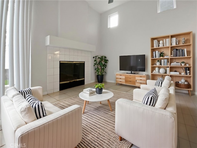 tiled living room featuring a tile fireplace and a towering ceiling