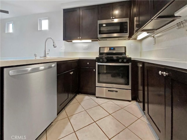 kitchen with sink, appliances with stainless steel finishes, dark brown cabinets, and light tile patterned floors