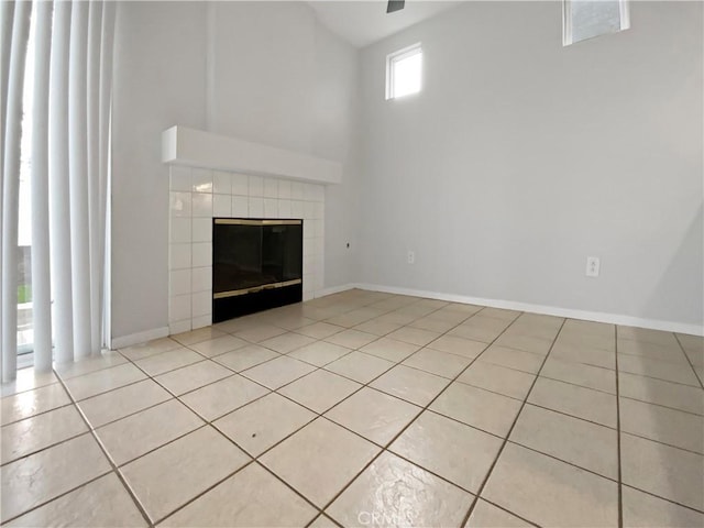 unfurnished living room with a tiled fireplace and light tile patterned floors