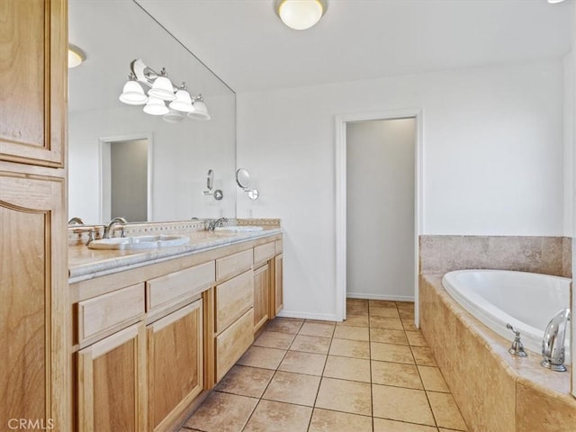 bathroom with double vanity, tiled tub, a sink, and tile patterned floors