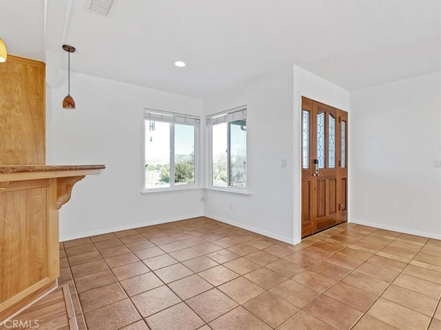 tiled entryway featuring recessed lighting, visible vents, and baseboards