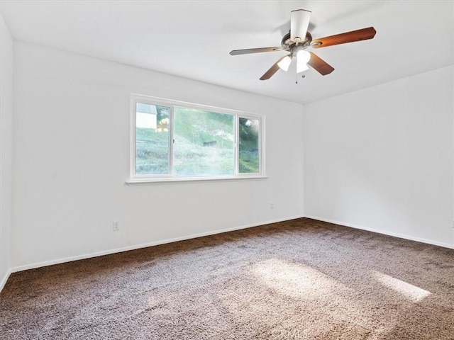 unfurnished room with carpet, a ceiling fan, and baseboards