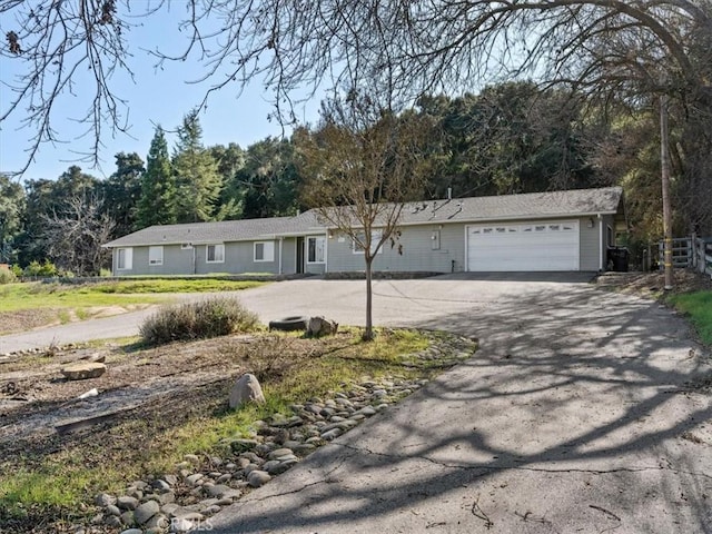 single story home with a garage and aphalt driveway