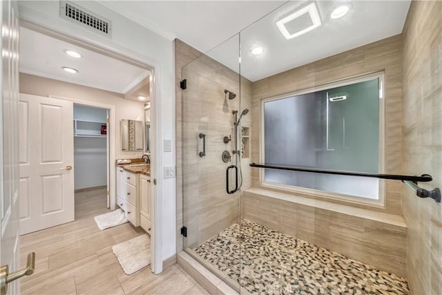 full bathroom with vanity, visible vents, recessed lighting, a shower stall, and a walk in closet