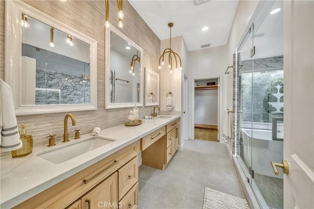 bathroom featuring a sink, double vanity, a stall shower, and visible vents