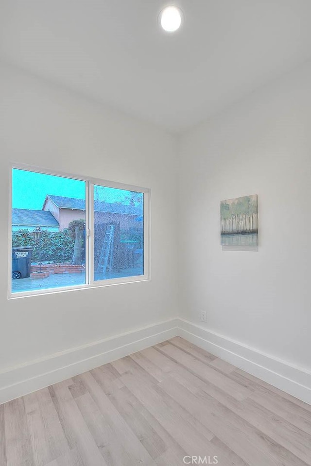 empty room featuring light wood-type flooring and baseboards