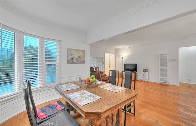 dining space featuring crown molding and light wood finished floors