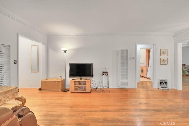 living area featuring visible vents, crown molding, and light wood finished floors