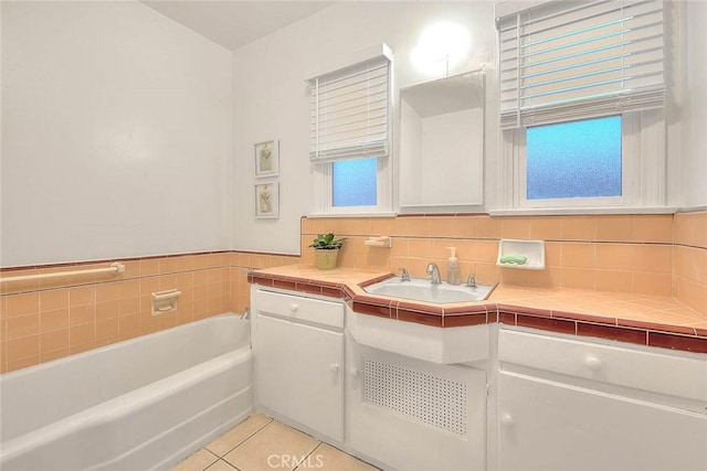 bathroom with decorative backsplash, vanity, a bath, and tile patterned floors