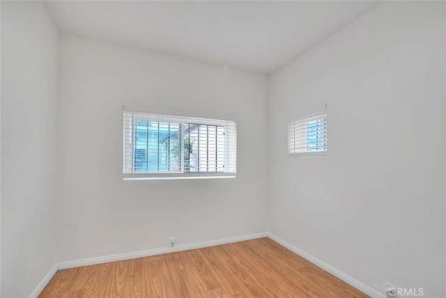 unfurnished room with baseboards and light wood-style floors