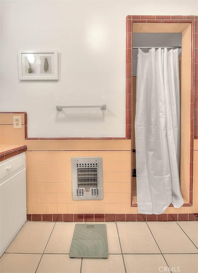 bathroom featuring tile patterned flooring, tile walls, and heating unit