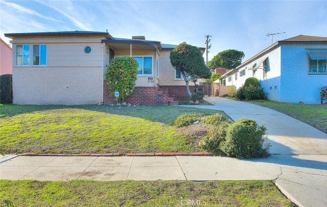 view of front facade featuring stucco siding and a front yard