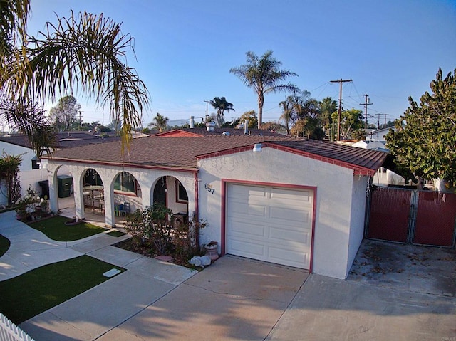 view of front of property with concrete driveway, fence, an attached garage, and stucco siding