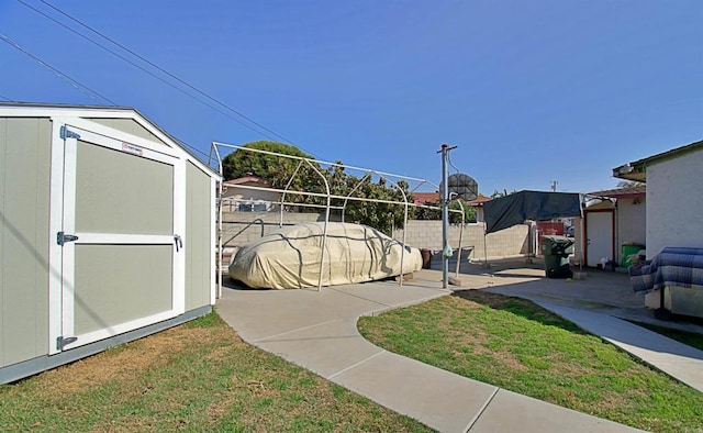 exterior space featuring a storage unit, an outdoor structure, and a fenced backyard