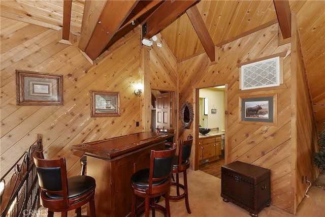 bar with wooden ceiling, lofted ceiling with beams, and wood walls