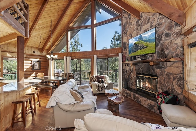 living room featuring hardwood / wood-style floors, a fireplace, a notable chandelier, wood ceiling, and beam ceiling