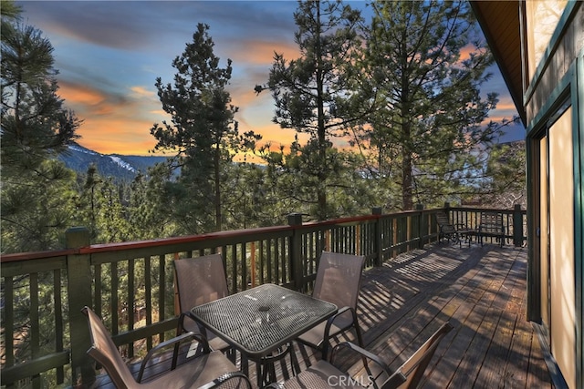 deck at dusk featuring a mountain view