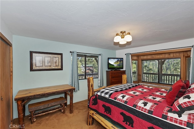 carpeted bedroom featuring access to exterior and a textured ceiling