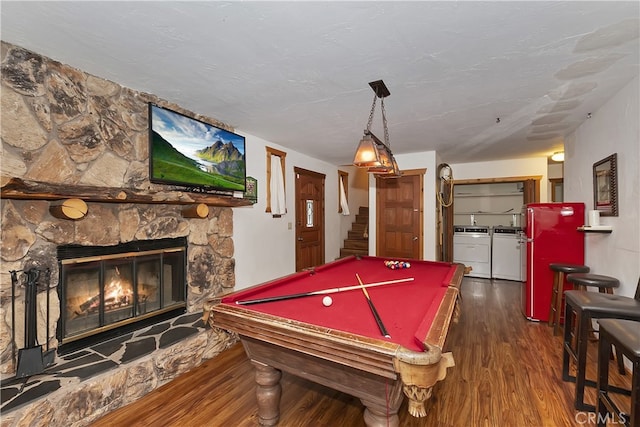 recreation room featuring washing machine and dryer, dark hardwood / wood-style flooring, pool table, and a fireplace