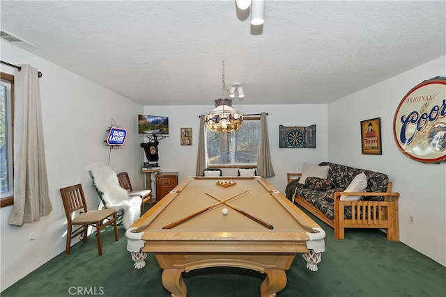 game room with pool table, a wealth of natural light, a textured ceiling, and dark colored carpet