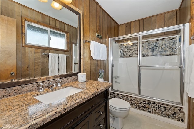 full bathroom featuring enclosed tub / shower combo, vanity, and wooden walls